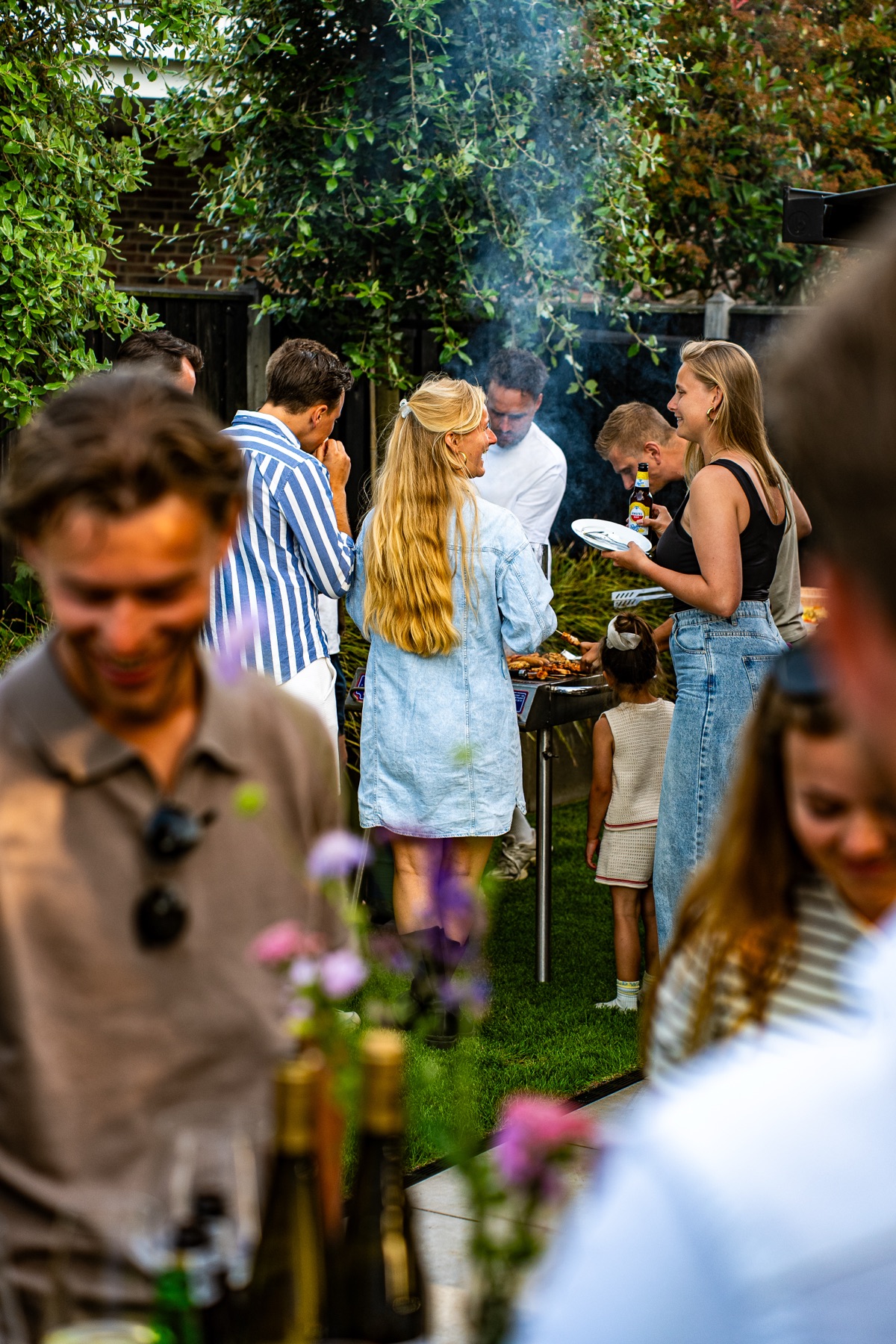 Gasten genieten samen van een barbecue in de tuin bij Slagerij Tomassen